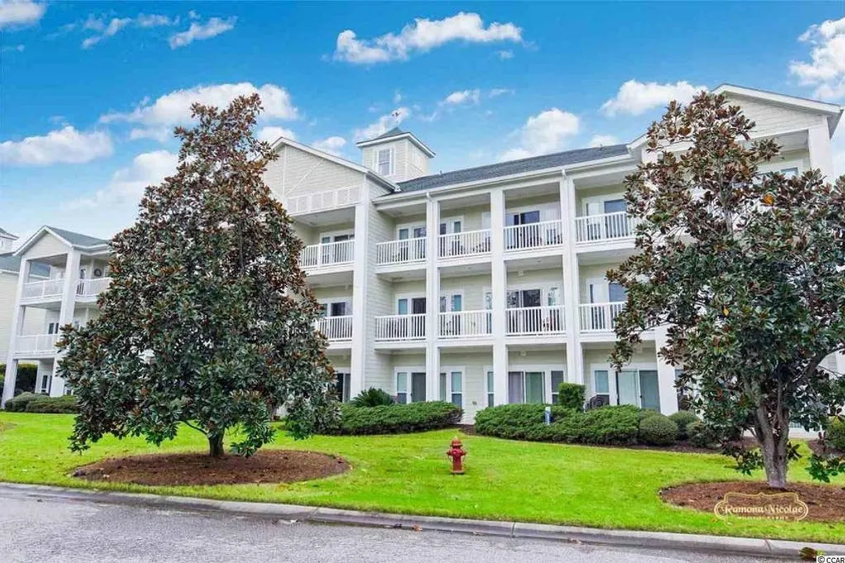 A sunlit exterior view of the resort’s balconies overlooking beautifully landscaped gardens. The scene conveys a sense of tranquility and community, with open spaces perfect for evening strolls or enjoying sunset views.